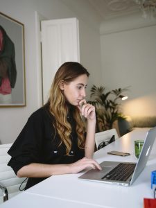 KinseyInvestigations.com Attorney Support - A woman works at a laptop computer.