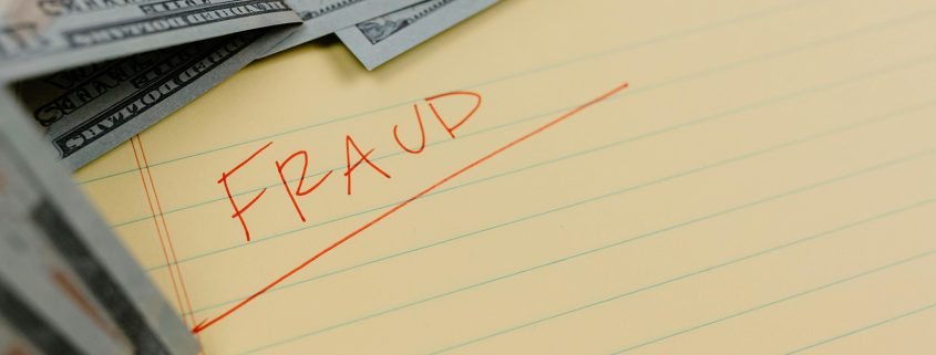 KinseyInvestigations.com Insurance Fraud Investigator - U.S. currency sits on top of a legal pad with the word fraud written across it.