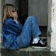 KinseyInvestigations.com Female Private Investigator Tips - A person with their hands over their face, sits in a doorway.