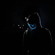 KinseyInvestigations.com Catfishing Detective - A person dressed in black wears a glowing mask.