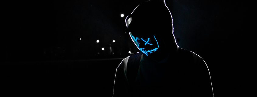 KinseyInvestigations.com Catfishing Detective - A person dressed in black wears a glowing mask.