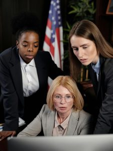 KinseyInvestigations.com Civil Litigation Support - Three professional women look at a laptop screen.