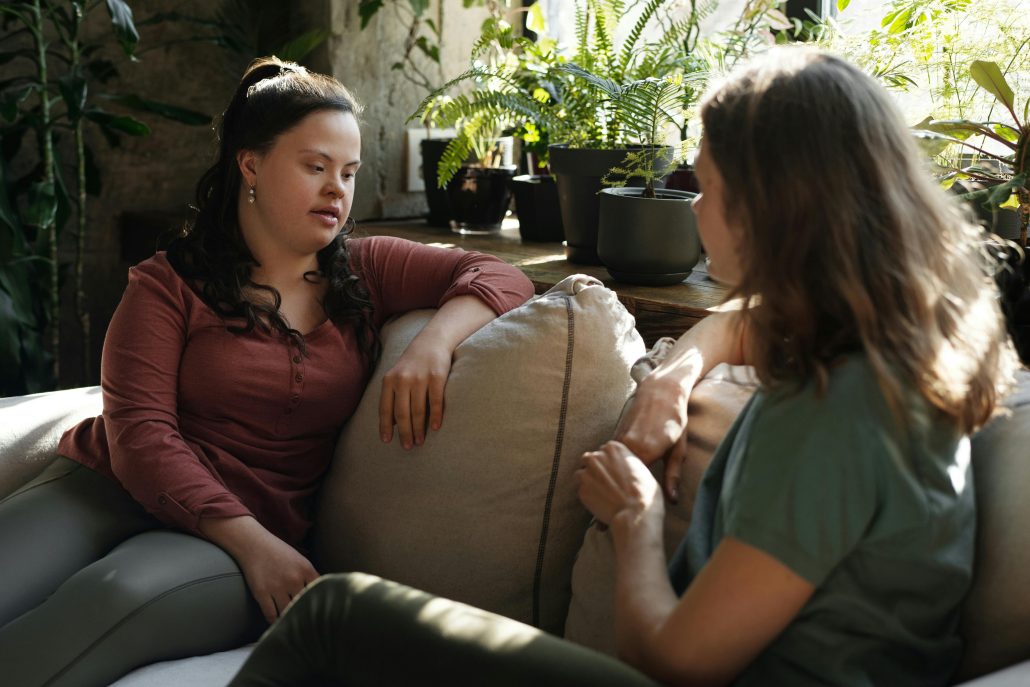 Two women conversing, plants in. background - Consult KinseyInvestigations.com. 