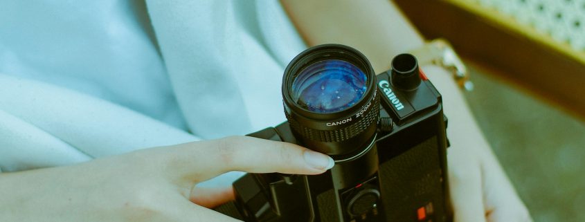 Woman holding high-tech video camera in her lap - Visit KinseyInvestigations.com .