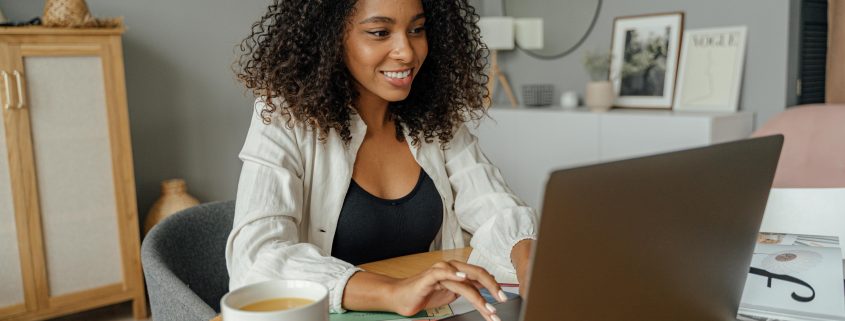 Smiling woman on her laptop - Visit KinseyInvestigations.com.